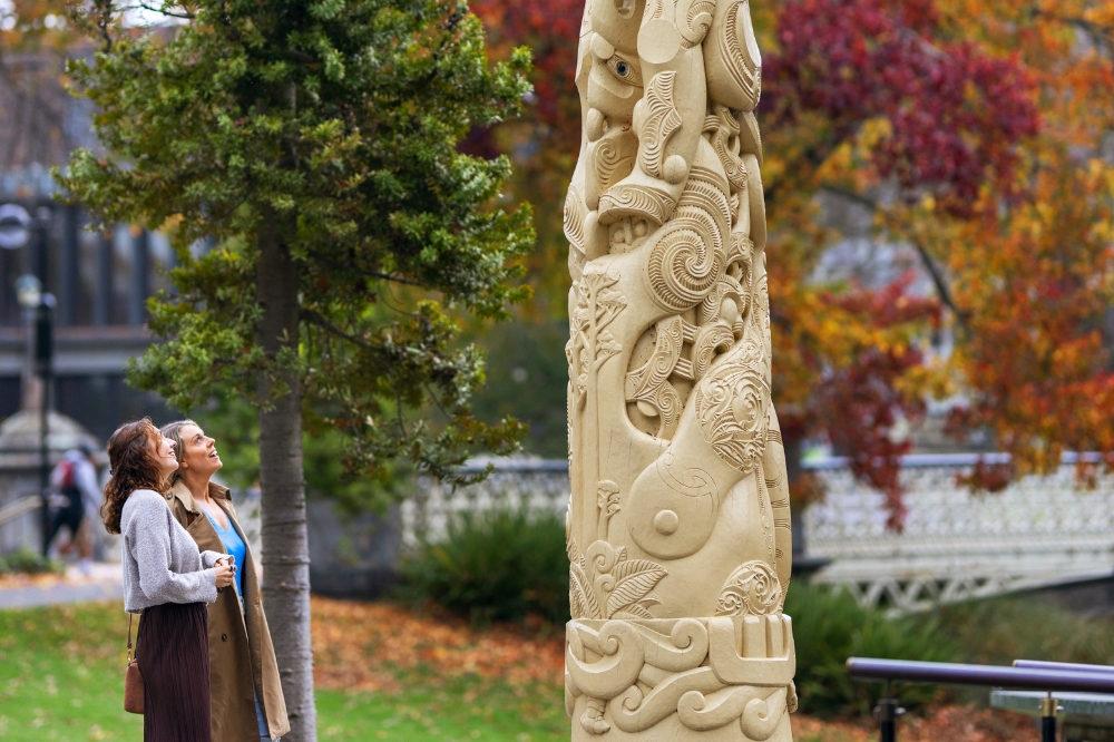 Two people gaze at a art piece