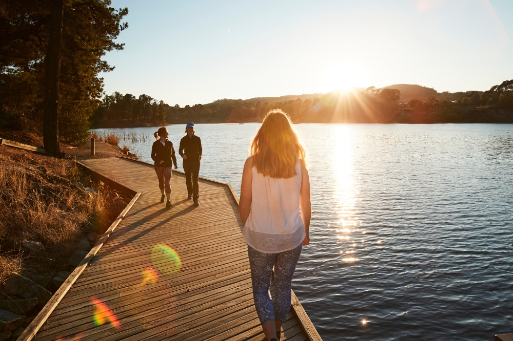 People walk around a lake on a boardwalk