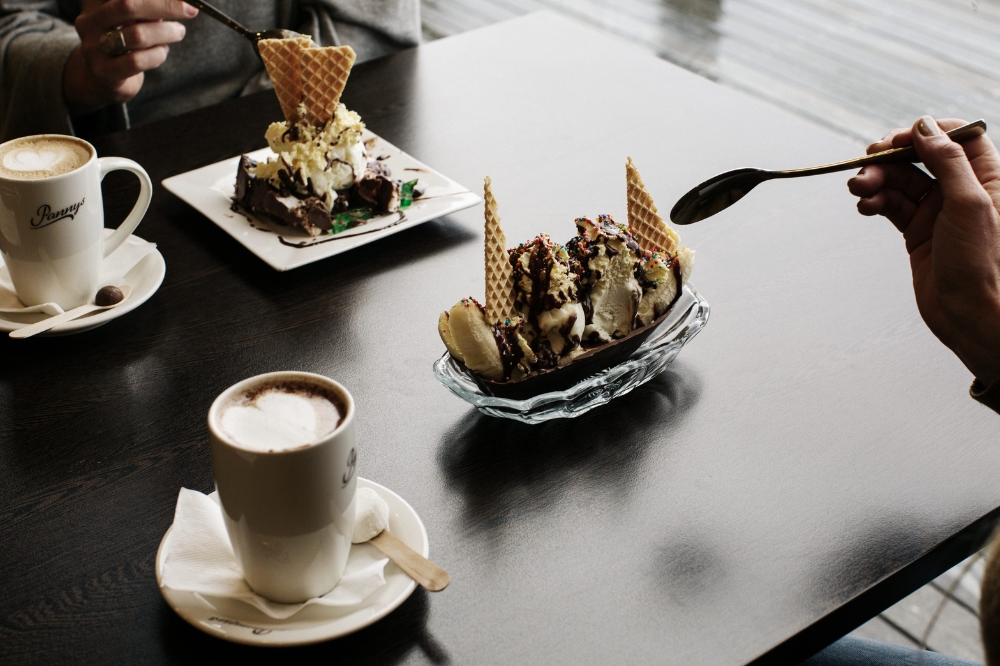 Two plates on the table with spoons about to eat chocolate ice cream treats