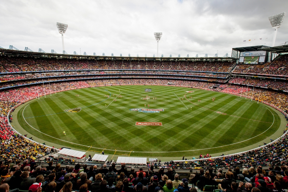 A large sports oval with stands filled with spectators.