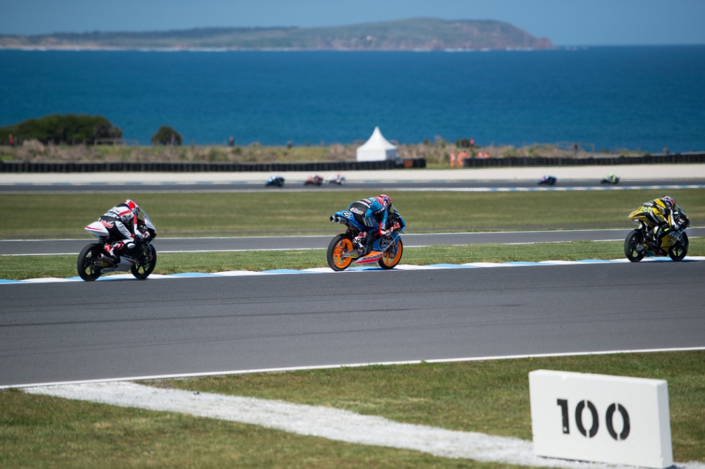 Motor cyclists race around an ocean side track