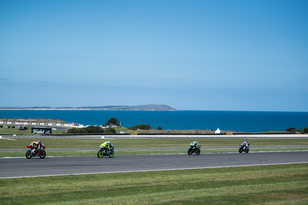 Motor cyclists race around an ocean side track